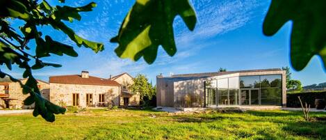Een modern huis met een stenen gebouw en een glazen uitbouw.