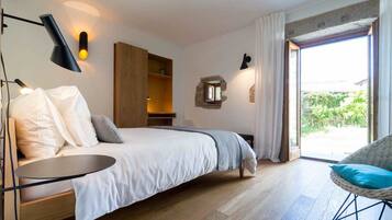 Een moderne slaapkamer met een bed, nachtkastje en een rieten stoel.