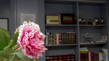 Una habitación con una estantería llena de libros y diplomas enmarcados.