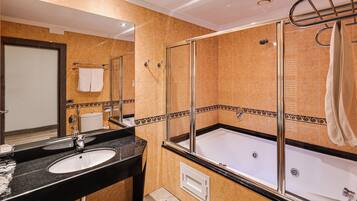 A modern bathroom with a double sink, a glass-enclosed shower, and a bathtub.