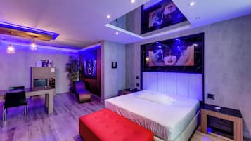 Een moderne slaapkamer met een bed, een bureau en een rode voetenbank.