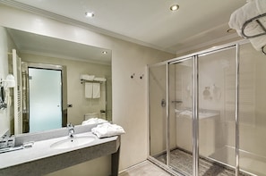 A modern bathroom with a glass shower enclosure, a large mirror, and a countertop with toiletries. - Zouk Hotel - Adults Only (Alcala de Henares)