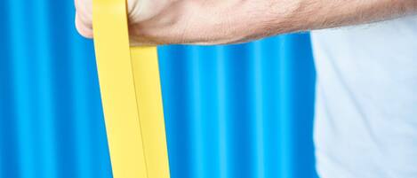 Una persona sostiene un objeto amarillo sobre un fondo azul.