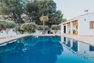 Una piscina al aire libre de temporada, sombrillas, tumbonas
