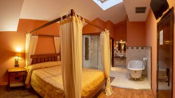 Una camera da letto con un letto a baldacchino, un lucernario, una doccia e un bagno con vasca.