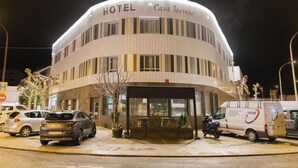 A hotel named "Casa Jacinto" with a curved facade, multiple windows, and a van parked in front. - Casa Jacinto Pamplona  (Burlada)