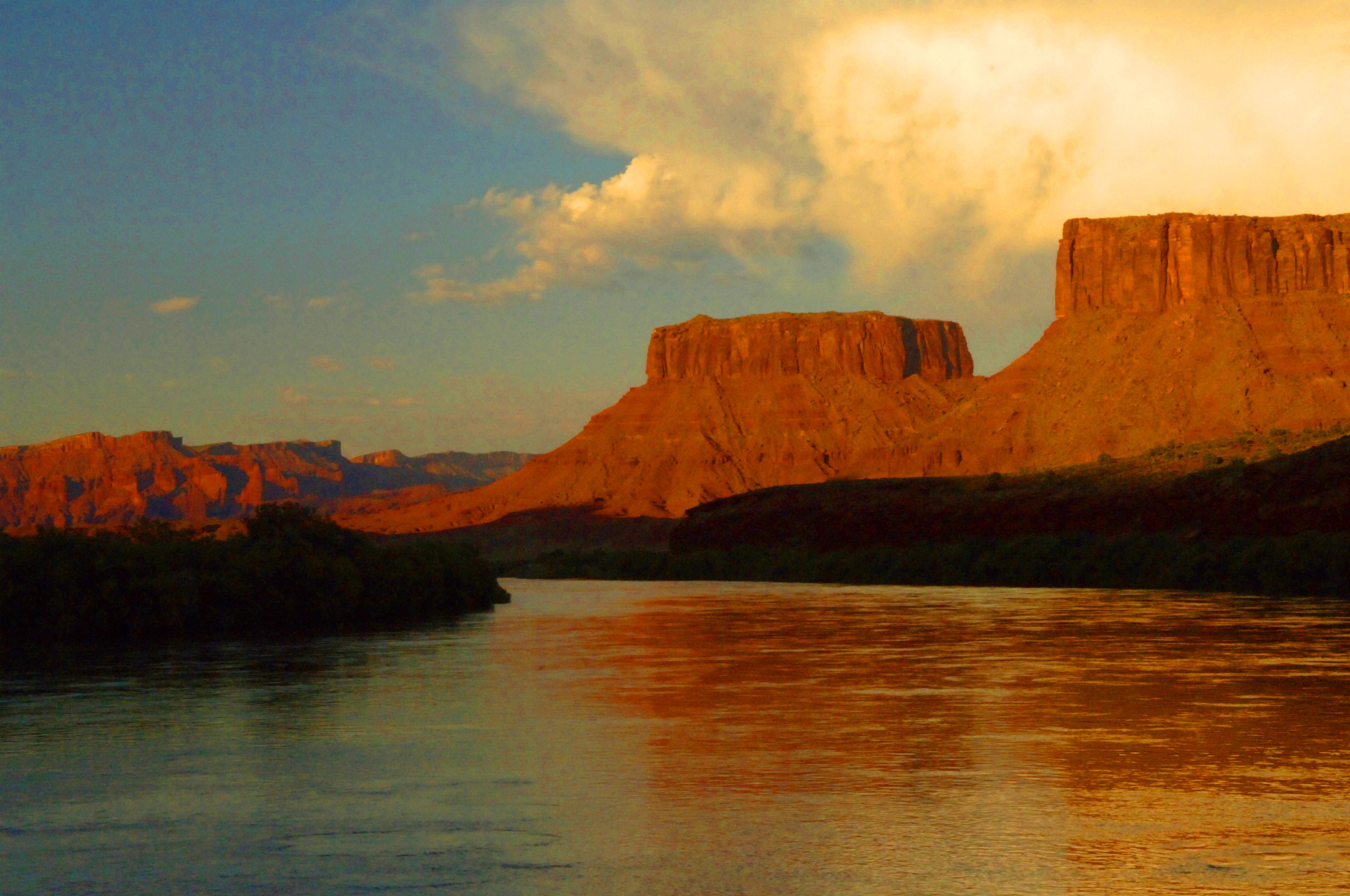 A river with a large rock formation in the background.