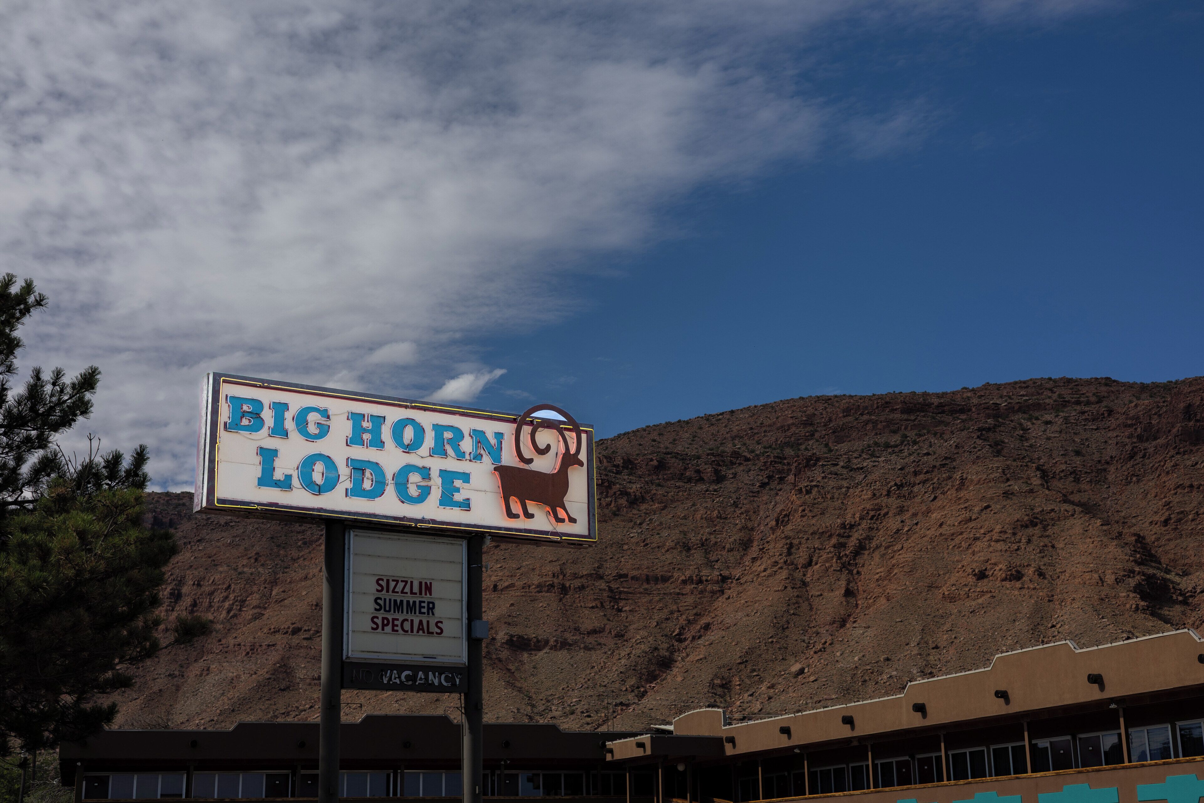 A sign for Big Horn Lodge with a mountain backdrop.