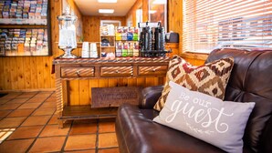 A cozy interior with a leather couch, a coffee machine, and a welcome sign.