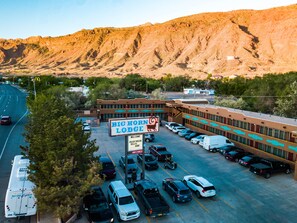 A parking lot with multiple vehicles and a building labeled "Big Horn Lodge." - Big Horn Lodge, a Dazzler Select by Wyndham (Moab)