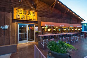 A Moab Grill restaurant with outdoor seating and a neon sign. - Big Horn Lodge (Moab)