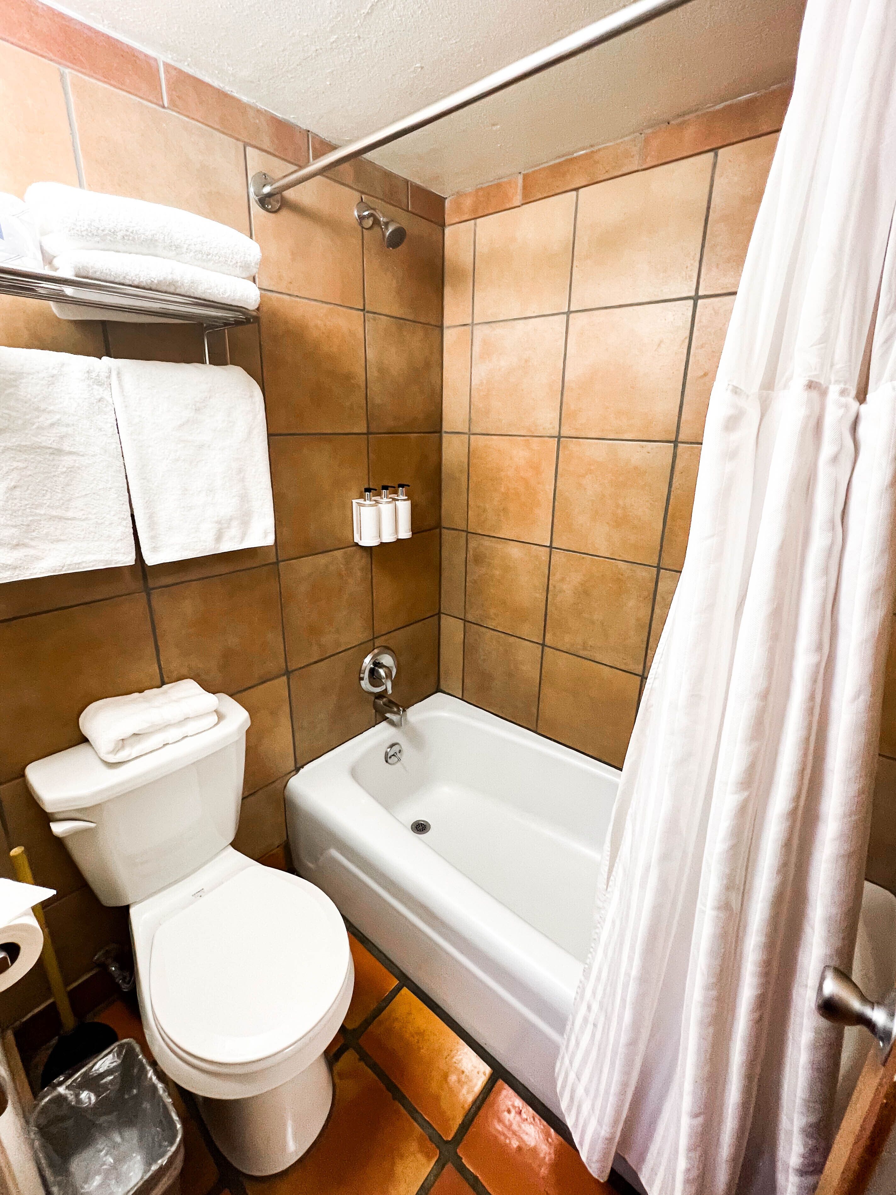 Une salle de bain équipée d’une baignoire, de toilettes et d’un porte-serviettes avec des serviettes.