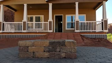 Une maison à deux étages dotée d’un porche couvert, de balustrades blanches et de fondations en pierre.