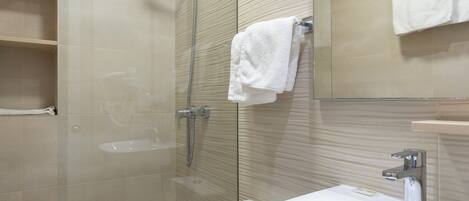 Un baño moderno con ducha de vidrio, inodoro blanco y lavabo.
