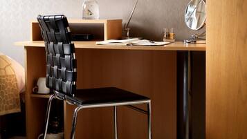 A modern study area with a wooden desk, a black and silver chair, a desk lamp, and a small mirror.