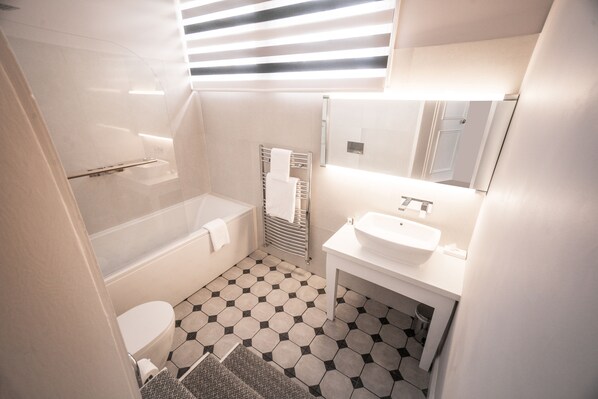 A modern bathroom with a bathtub, toilet, and sink. - Steventon House Hotel (Abingdon)