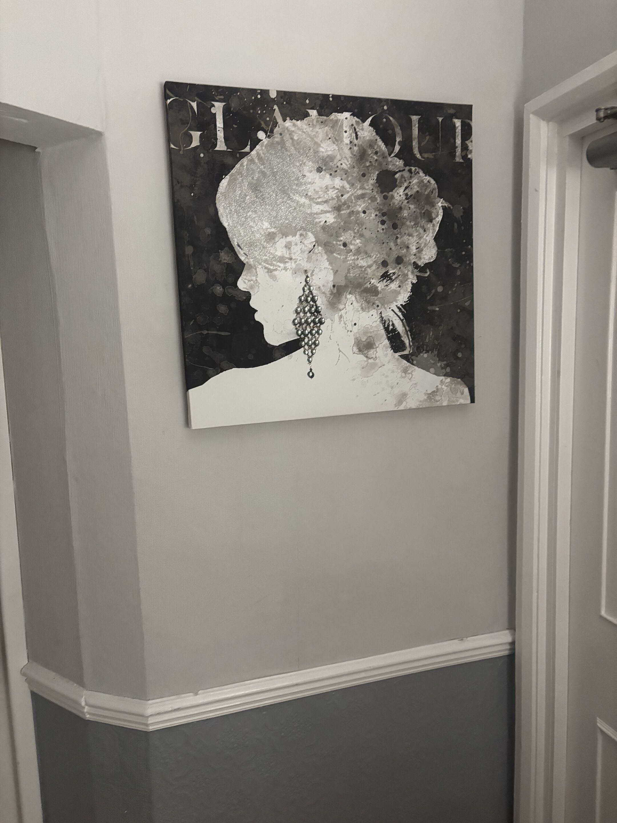 Una pared con un cuadro que muestra el perfil de una persona con un arete grande.