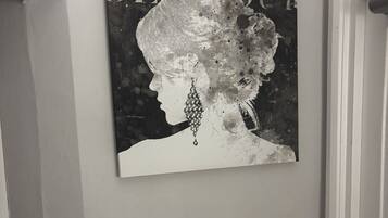 Una pared con un cuadro que muestra el perfil de una persona con un arete grande.