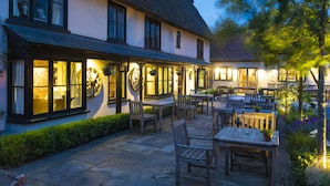 A traditional building with large windows, wooden furniture, and a thatched roof.