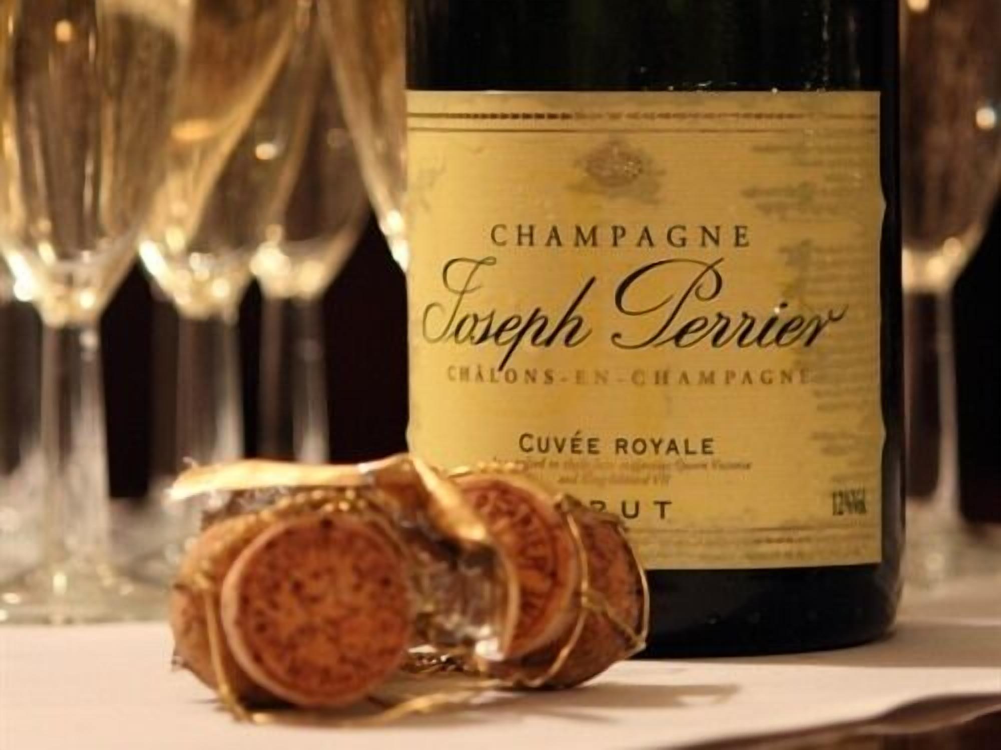 A bottle of Champagne Joseph Perrier, a corkscrew, and several glasses.