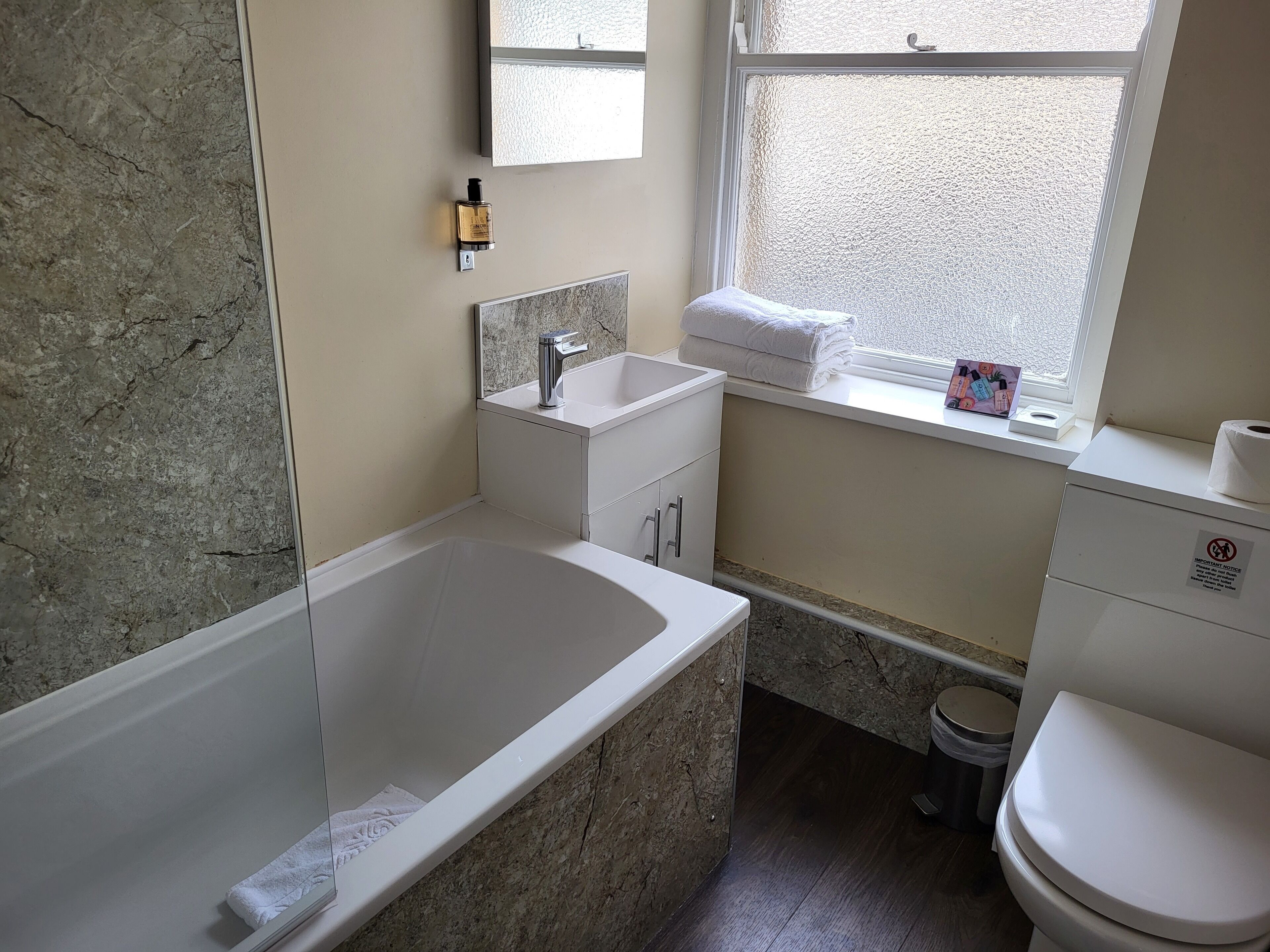 A bathroom with a bathtub, sink, and toilet.