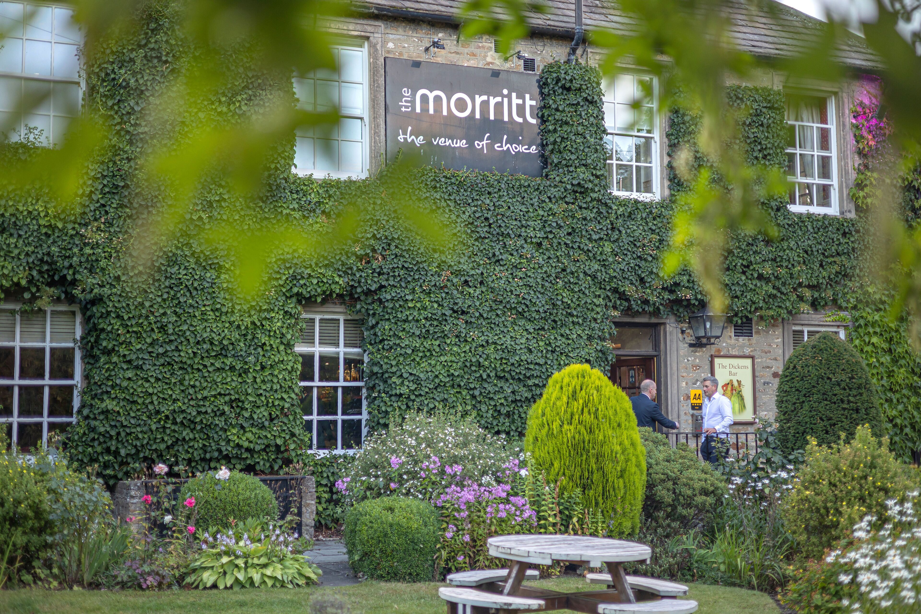A building with ivy-covered walls and a sign reading "the morrtt the venue of choice."