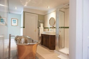 Un baño moderno con una bañera independiente, un box de ducha de vidrio y un lavamanos con espejo.