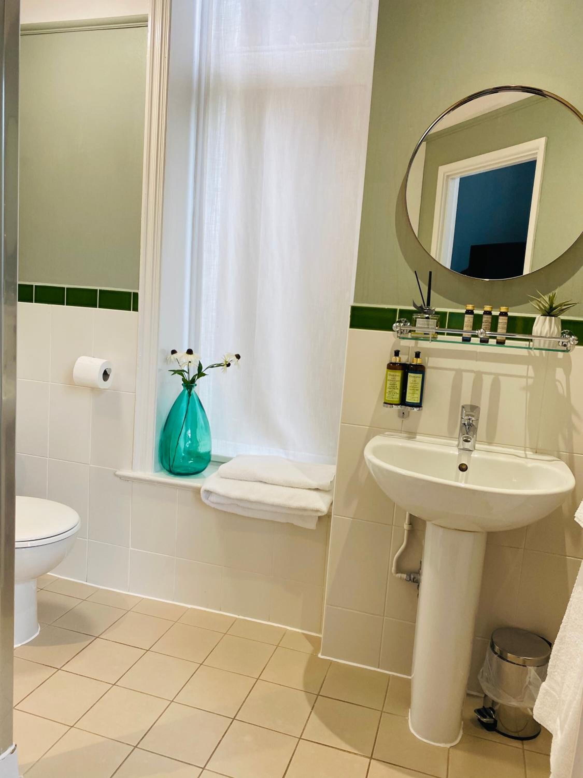A bathroom with a toilet, sink, and shower curtain.