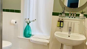 A bathroom with a toilet, sink, and shower curtain.