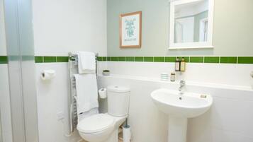 Un baño con inodoro, lavabo y una cita enmarcada en la pared.