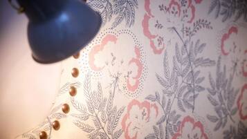 Detalle de una tela estampada con motivos florales y una lámpara.