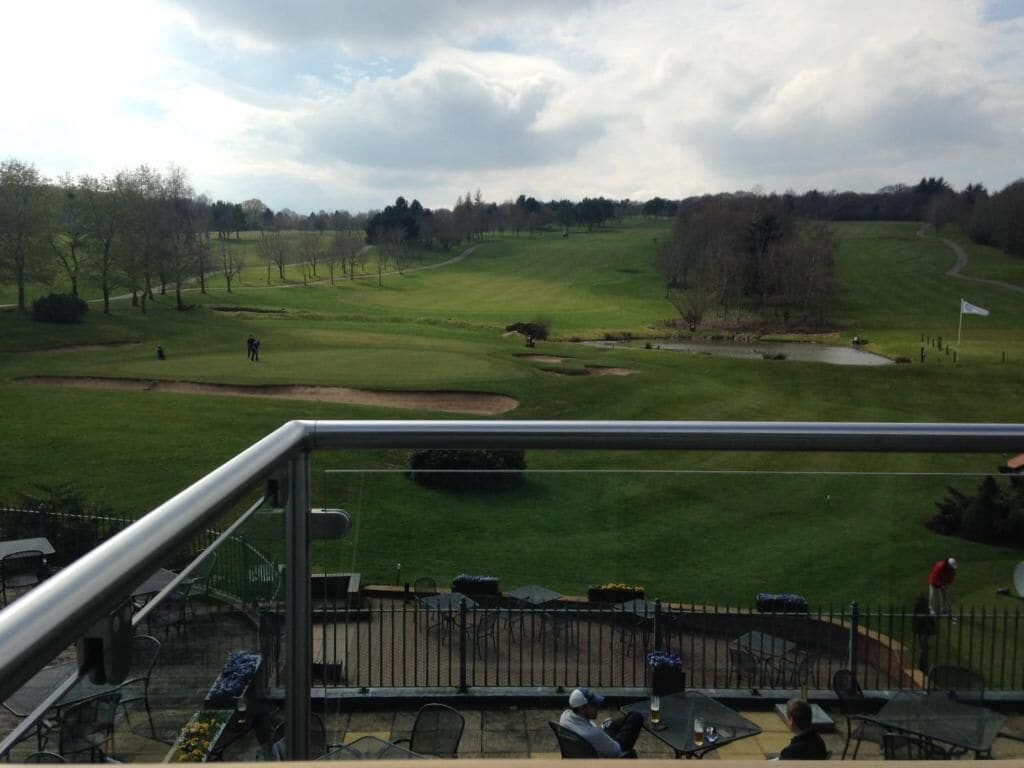 A golf course with a view from a balcony.