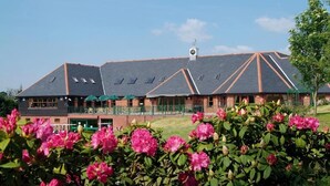 A building with a sloped roof, multiple windows, and a clock tower. - Wharton Park Golf & Country Club (Bewdley)