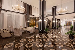 A spacious lobby with a checkered floor, elegant seating, and chandeliers. - Ramada Plaza Fond du Lac (Fond du Lac)