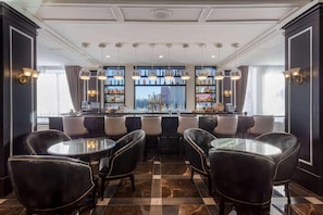 A bar area with a long counter, multiple shelves of bottles, and leather chairs. - Ramada Plaza Fond du Lac (Fond du Lac)
