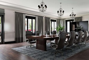 A conference room with a long table, multiple chairs, a chandelier, and a large screen. - Ramada Plaza Fond du Lac (Fond du Lac)