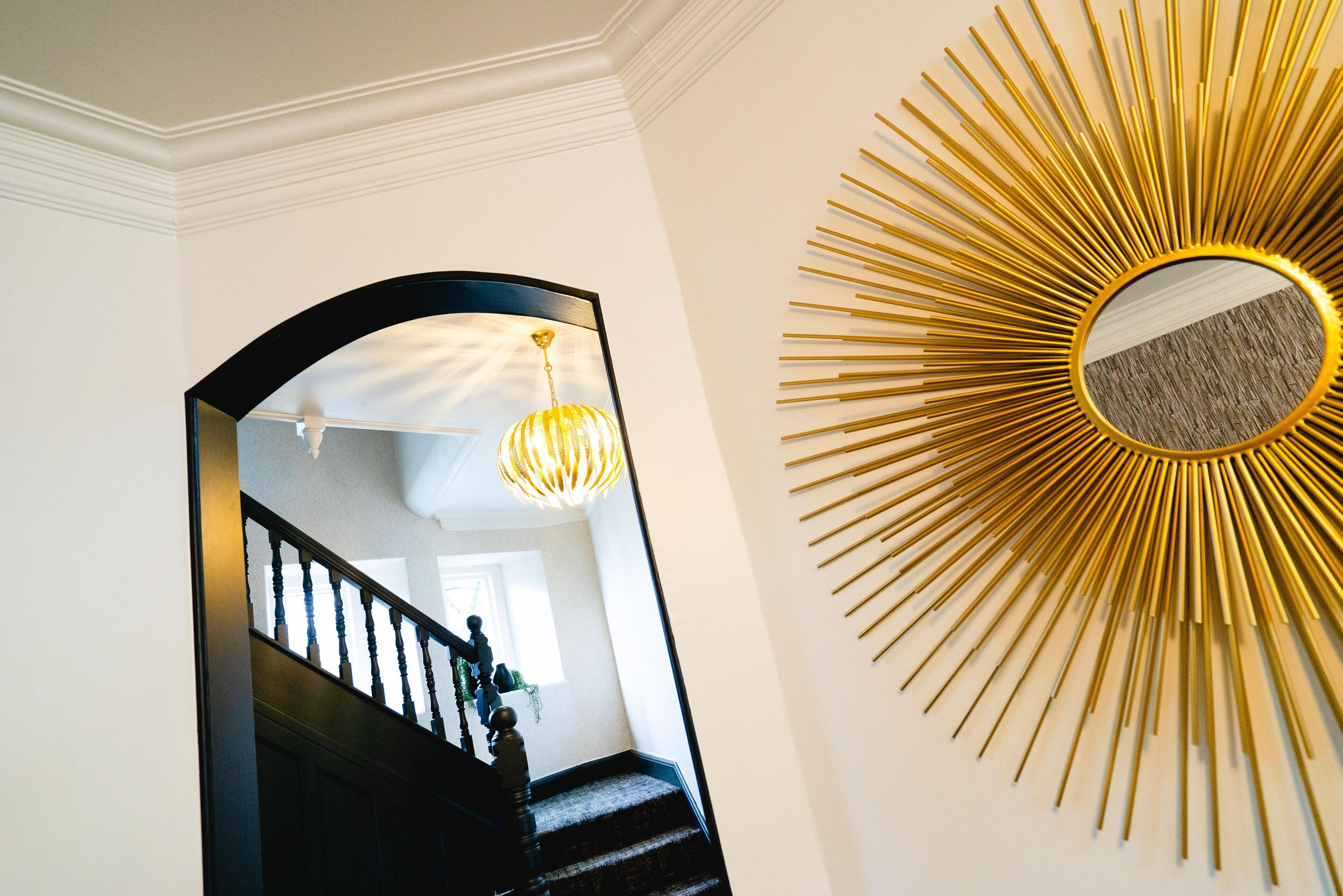 A staircase with a black railing and a hanging light fixture.