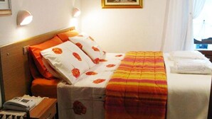 A hotel room with a bed, a nightstand, and a wall-mounted lamp. - Hotel Bucaneve (Pre-Saint-Didier)