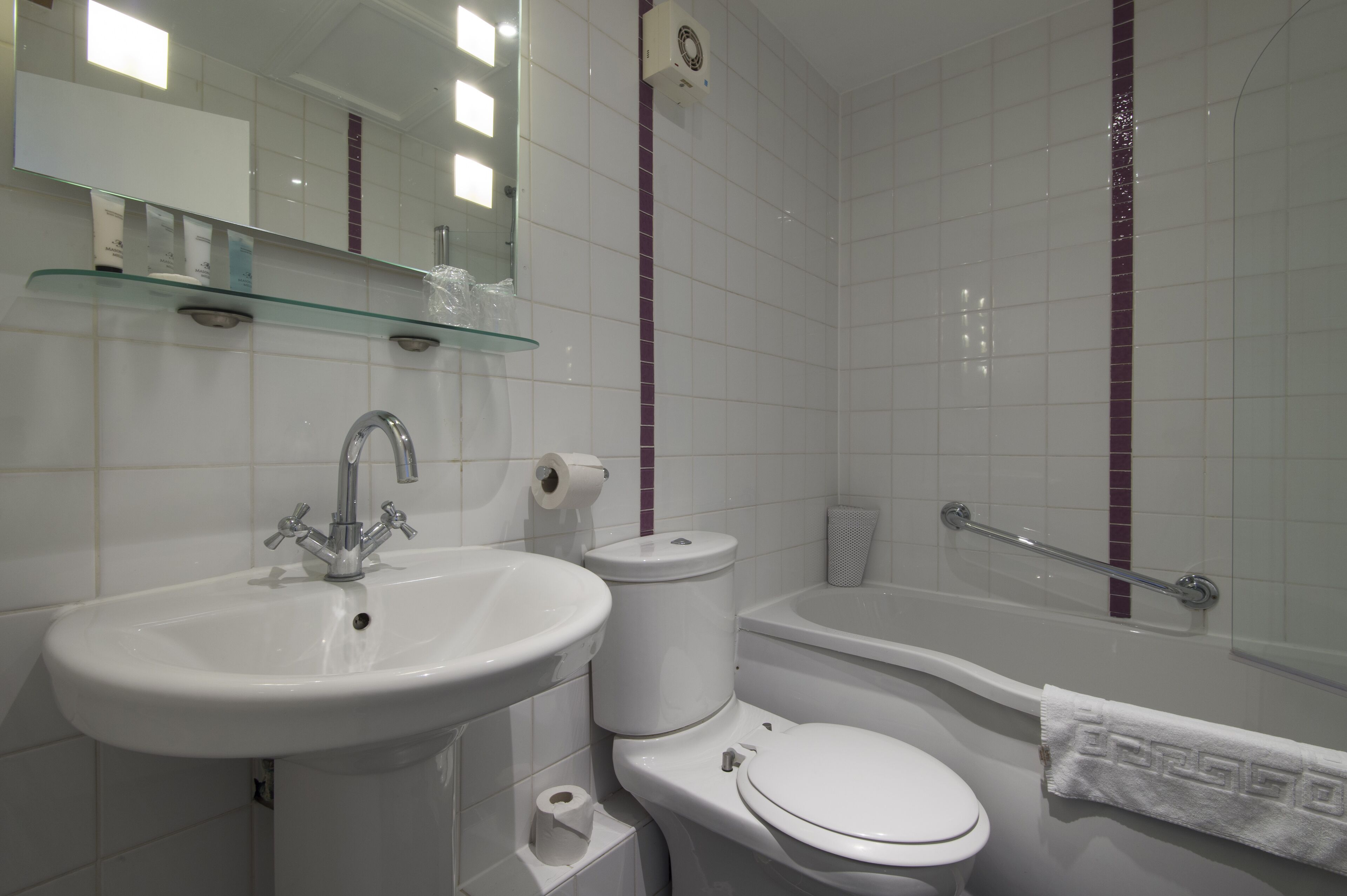 Une salle de bain avec un lavabo, des toilettes et une baignoire.