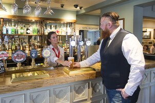 Uma área de bar com várias torneiras de cerveja e um balcão.