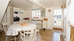 A kitchen with a dining table, chairs, and a microwave.