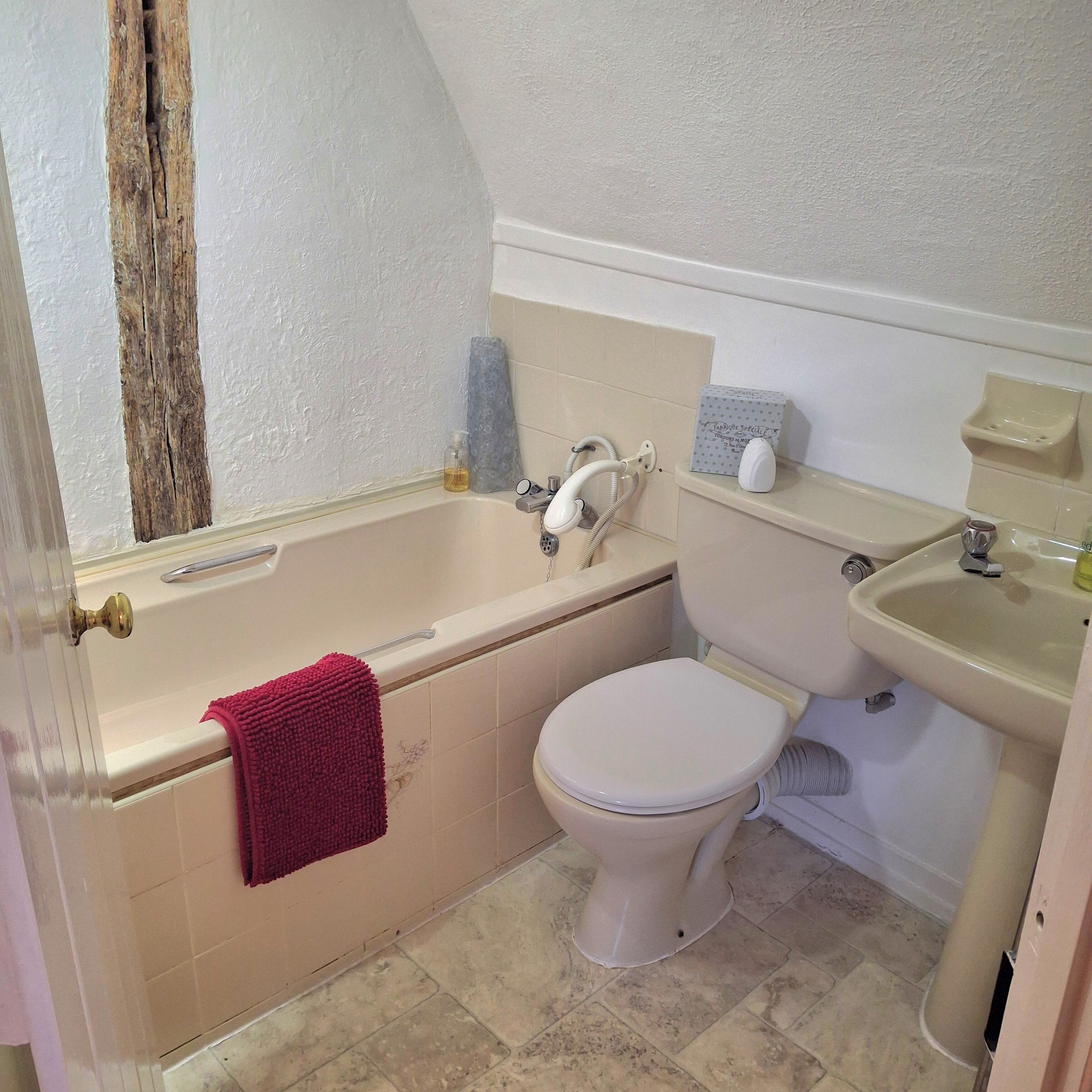 A bathroom with a bathtub, toilet, and sink.