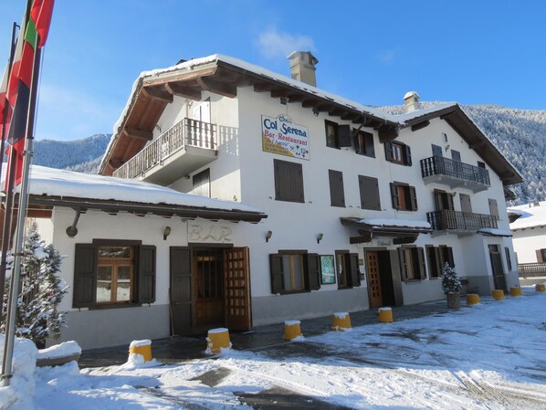 Un edificio de dos pisos con un letrero que dice "Col Hotel Serene Restaurant" y balcones.