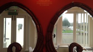 Two ornate swan-shaped mirrors on a red wall with a sign above them reading "Lynebank House Premier Guest House". - Lynebank House Hotel Bed & Breakfast (Carlisle)