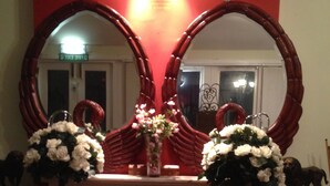 A fireplace with two large mirrors above it, a vase with flowers, and a small statue on the mantel. - Lynebank House Hotel Bed & Breakfast (Carlisle)