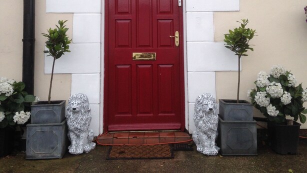 A red door with a white-framed entrance, flanked by two potted plants. - Lynebank House Hotel Bed & Breakfast (Carlisle)