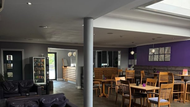 Un espace de détente moderne, doté de différents types de sièges, d’un coin café et offrant une vue sur l’espace extérieur.