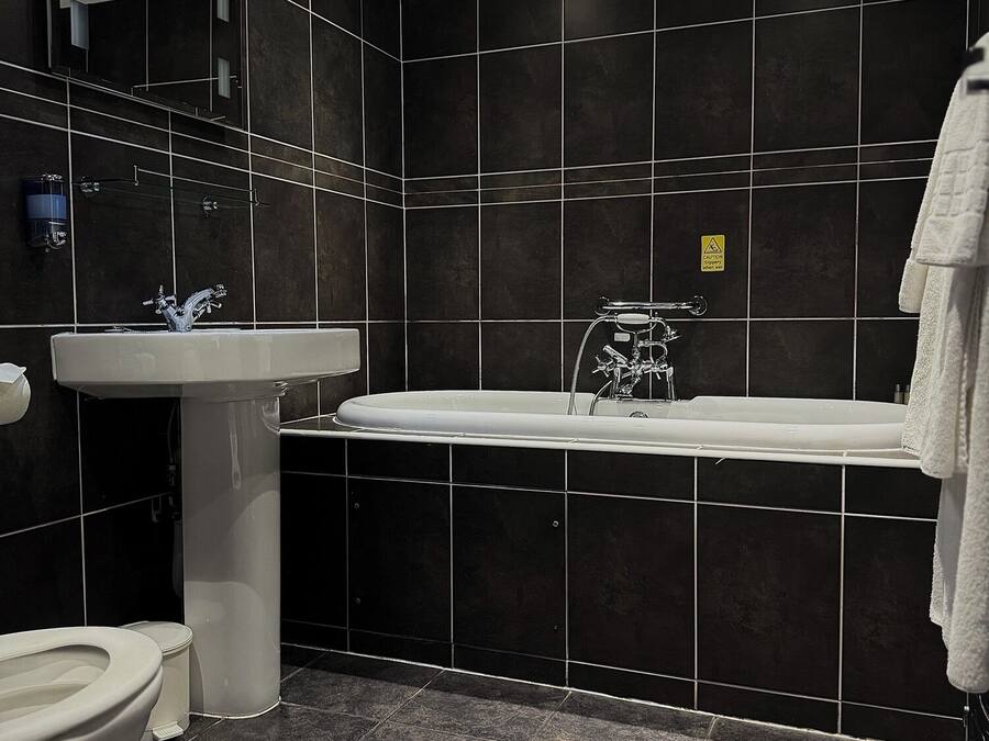 A modern bathroom with a bathtub, sink, and toilet.