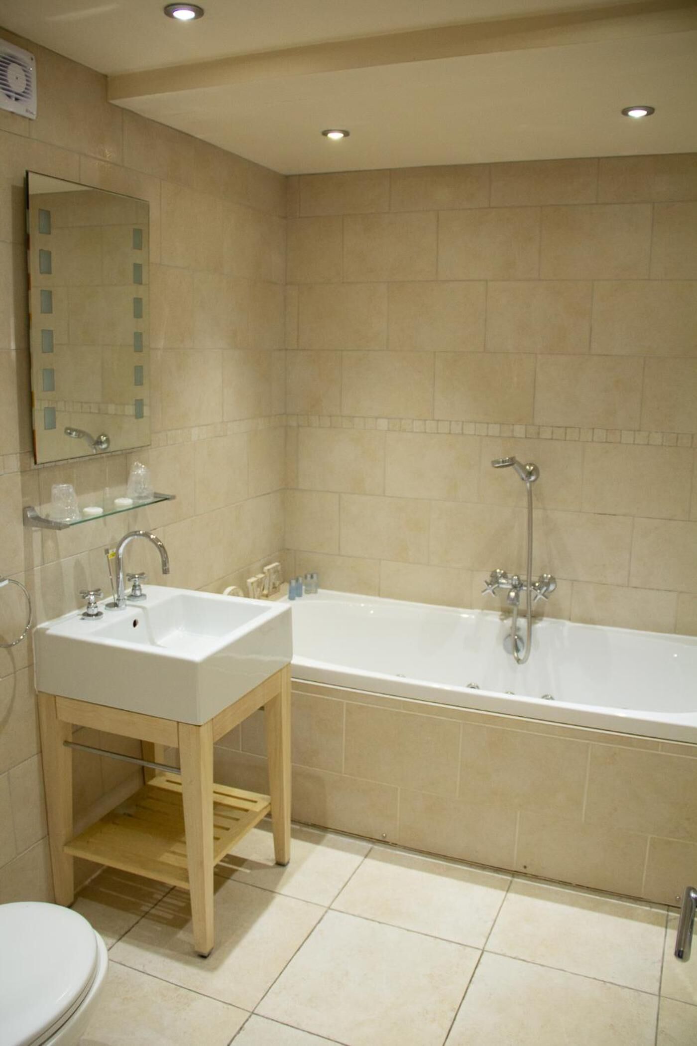 A bathroom with a white sink, mirror, and bathtub.