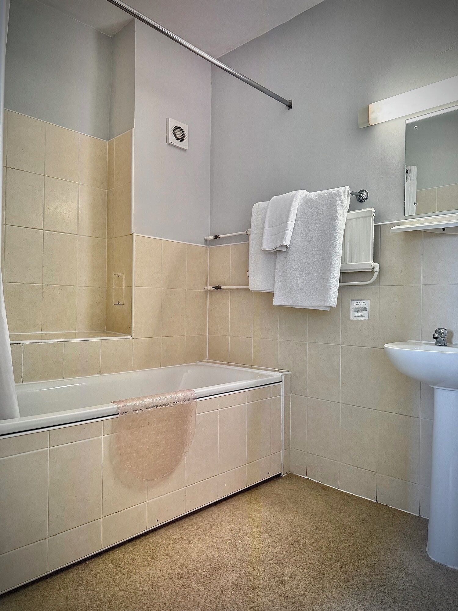 Une salle de bain avec une baignoire, un lavabo et un porte-serviettes.